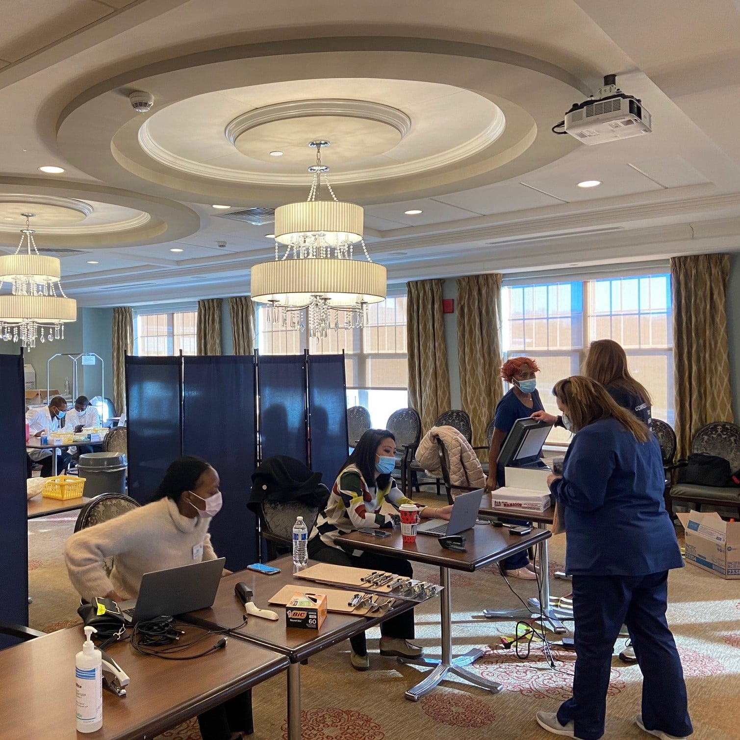 Team members walking up to the COVID-19 vaccine registration tables.