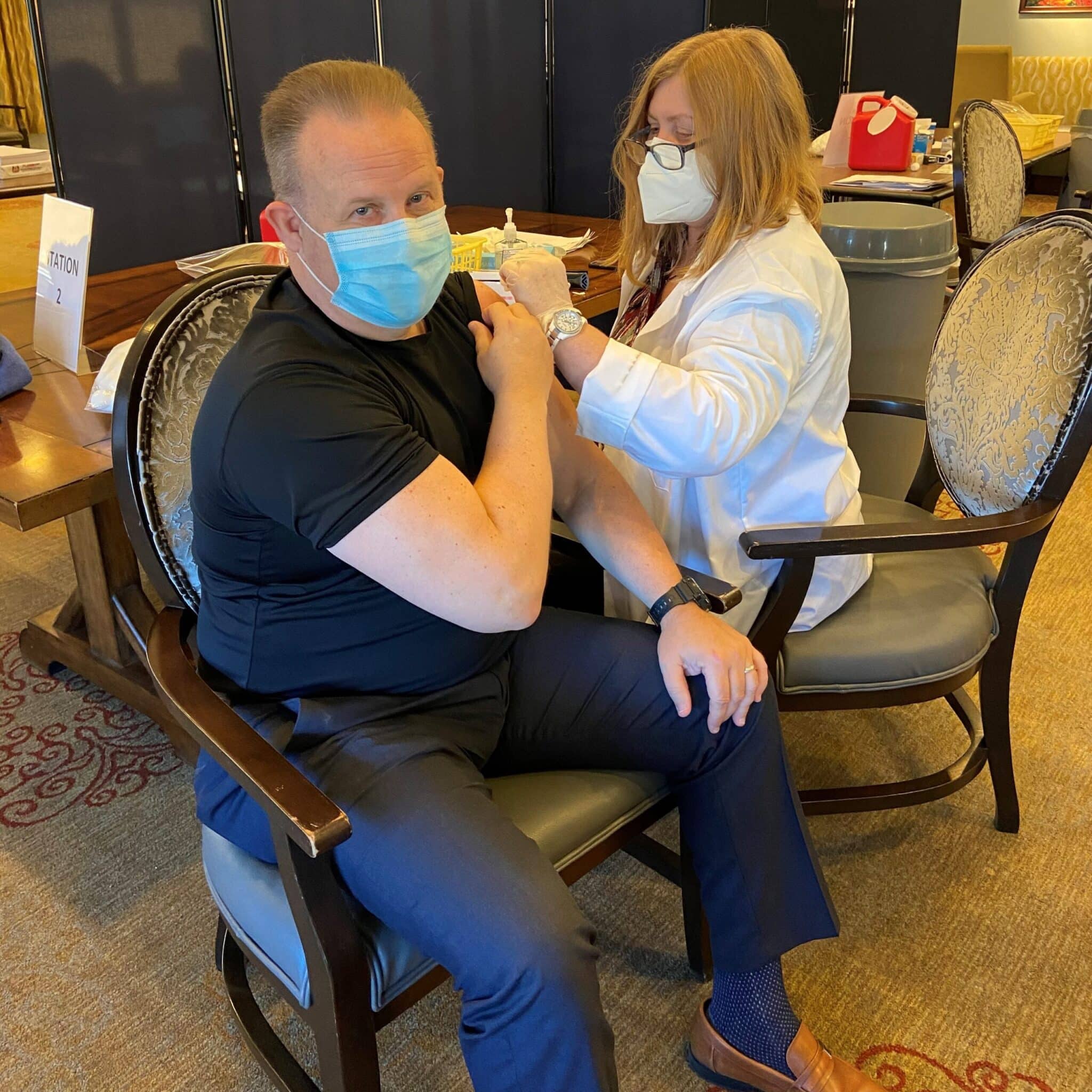 Lutheran Social Ministries of Maryland's Vice President of Operations, Ken Connelly, sitting in a chair as he's about to get his COVID-19 vaccine.