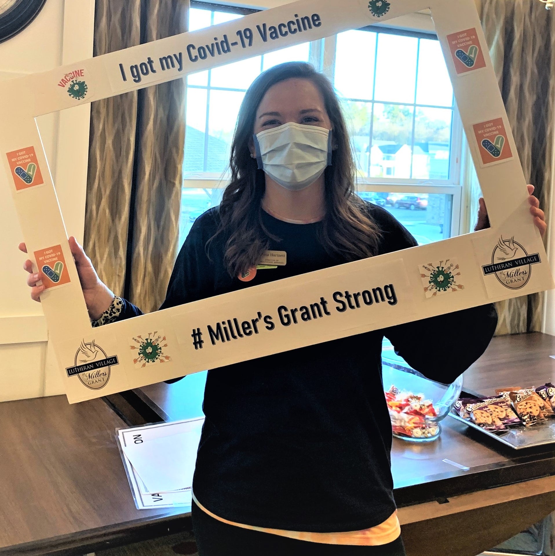 LVMG's Director of Health Care/Assisted Living holding an I Got My COVID-19 Vaccine selfie frame in front of her.