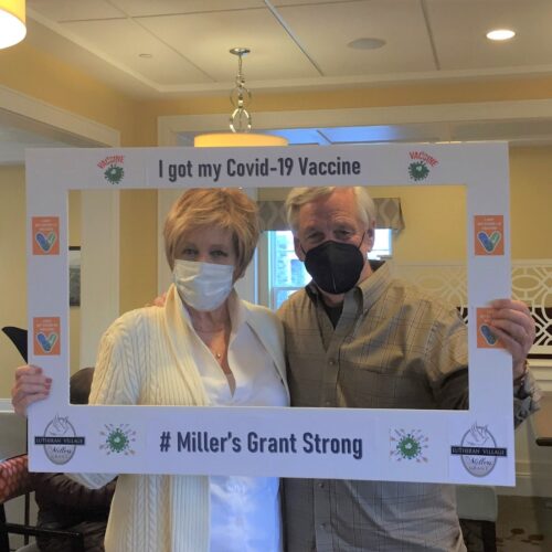An independent living couple of LVMG holding an I Got My COVID-19 Vaccine selfie frame in front of them.