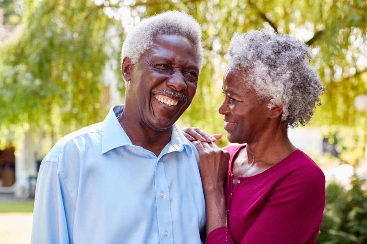 A senior African-American couple enjoying their senior living communities outdoors.