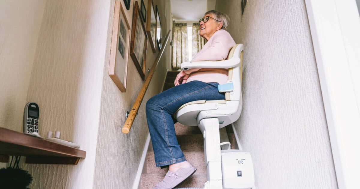 Older adult using a home renovation stair climbing chair to help with aging in place